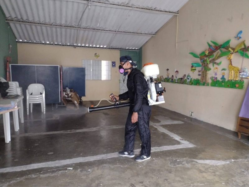 Técnico de FUMISEG con equipo de protección fumigando un local en Bucaramanga